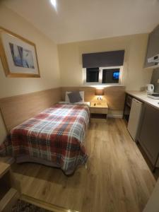 Habitación pequeña con cama y cocina en The Abbey House Hotel en Reading