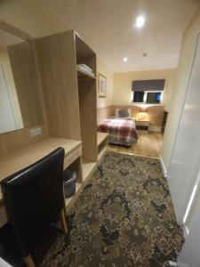 ein Hotelzimmer mit einem Bett, einem Schreibtisch und einem Stuhl in der Unterkunft The Abbey House Hotel in Reading