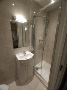 a bathroom with a sink and a shower at The Abbey House Hotel in Reading