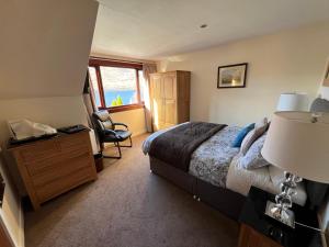 1 dormitorio con cama, escritorio y silla en Stronchreggan View Guest House, en Fort William