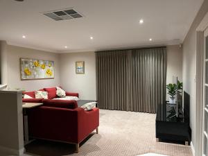 a living room with a red couch and a window at Applecross 2 Bedrooms by Swan River in Perth