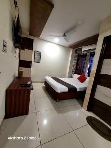 una camera d'albergo con letto e TV di Hotel Mehar Residency a Indore