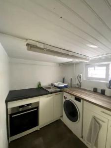 uma cozinha com um lavatório e uma máquina de lavar roupa em Appartement spacieux proche de paris em Carrières-sur-Seine