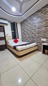 una camera con un letto con un muro di mattoni di Hotel Mehar Residency a Indore