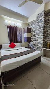 una camera da letto con un grande letto con un cuscino rosso di Hotel Mehar Residency a Indore