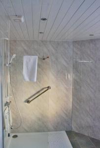 um chuveiro com uma porta de vidro na casa de banho em The Hopetoun Arms Hotel em Leadhills
