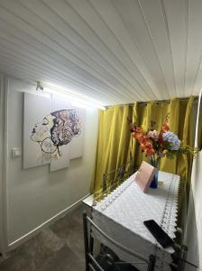 um quarto com uma secretária com uma mesa com flores em Appartement spacieux proche de paris em Carrières-sur-Seine