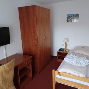 a bedroom with a bed and a desk and a cabinet at Hotel Zittauer Hütte in Kurort Jonsdorf
