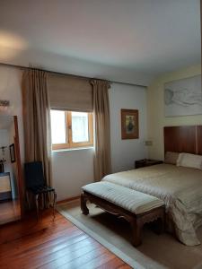 Casa Mali في Quinta do Conde: غرفة نوم بسرير كبير ونافذة