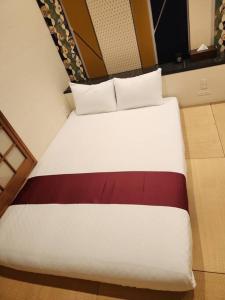 een slaapkamer met een groot wit bed met 3 kussens bij The year 2024 is in the discount period! Near USJ in Osaka