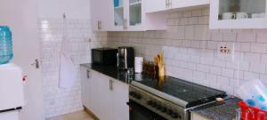 a kitchen with white tiled walls and a counter top at 6th Avenue Court in Nairobi