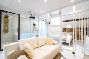 ein Wohnzimmer mit einem weißen Sofa und ein Schlafzimmer in der Unterkunft Oasis Chic - Spa privé & Cinéma in Reims