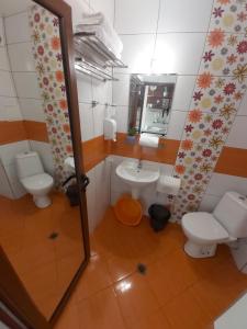 a bathroom with a sink and a toilet and a mirror at Guest House Skalite in Sozopol