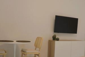 Habitación con 2 sillas y TV en la pared. en Apartamento Lapa, en Tías