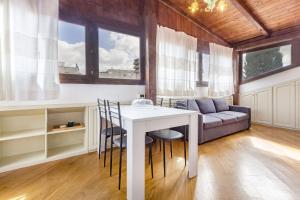 salon ze stołem, krzesłami i kanapą w obiekcie Exclusive Roth Apartments w mieście Sassari