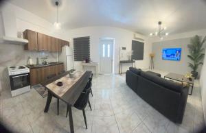 uma cozinha e sala de estar com uma mesa e um sofá em Blue Mind House em Néa Kíos