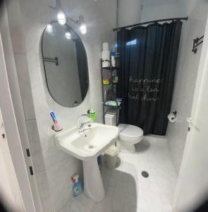 W łazience znajduje się umywalka, toaleta i lustro. w obiekcie Blue Mind House w mieście Nea Kios