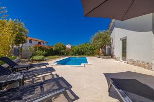 basen z 2 krzesłami i parasolem w obiekcie Holiday house KAI with private pool w mieście Pinezići