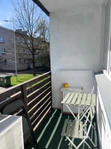 a small balcony with a table and a chair at Leola Center Apartment in Viljandi