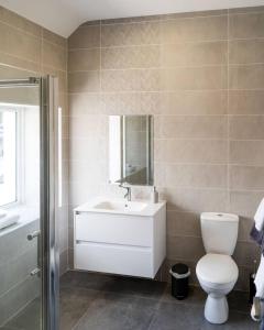 Bridge Inn Studio Apartments في دونيجال: حمام مع حوض أبيض ومرحاض