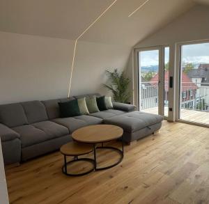 a living room with a couch and a table at Penthouse Alpenblick in Kempten +5 photos