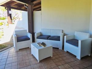een patio met stoelen, een bank en een tafel bij Agriturismo Ninea in Capo Vaticano