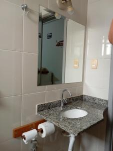 a bathroom with a sink and a mirror at Mariachis Hotel in Passos