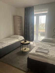 um quarto com 2 camas, uma mesa e uma janela em Penzion Grusbach em Znojmo