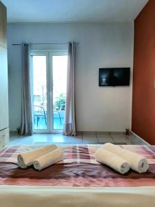 a bedroom with a bed with two towels on it at Crystal Cherry Apartment in Preveza