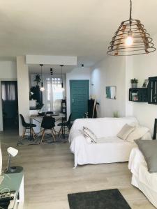 a living room with a white couch and a table at Apartamento Cloe con terraza y vistas al Mar in El Puerto de Santa María