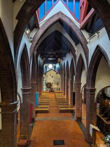 The Shrine of Our Lady of Walsingham في ليتل والشنغهام: ممر في كنيسة مع مقاعد خشبية