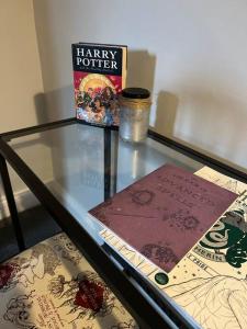 a glass table with a book and books on it at Potters Retreat- Warner Bros Studios and London in Watford
