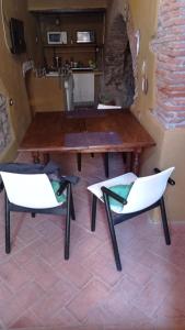 una mesa y 2 sillas blancas en una habitación en VIA VARESE 4 en Castagneto Carducci