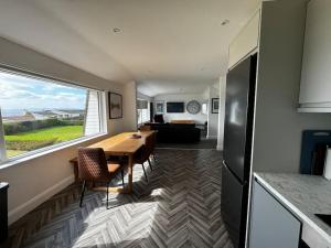a kitchen and dining room with a table and a window at 1 Seaview Portstewart in Portstewart