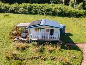 a small house with a solar roof in a field at Byron Hinterland Rustic Off Grid Cabin in Rosebank