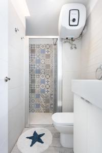Un baño con inodoro blanco y ducha. en Home2Book Comfy Apartment Las Galletas Beach, en Las Galletas