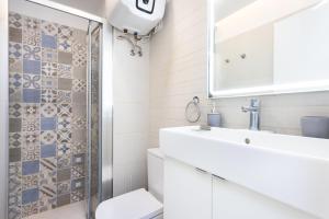 Un baño con lavabo, inodoro y espejo. en Home2Book Comfy Apartment Las Galletas Beach, en Las Galletas 18 fotos más
