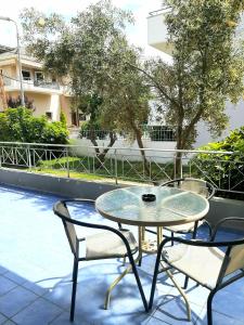 a glass table and two chairs on a patio at Crystal Cherry Apartment in Preveza