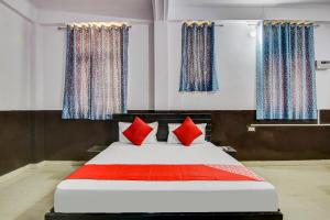 a bedroom with a large bed with red pillows at OYO Flagship Hotel Golden Inn in Bhiwadi