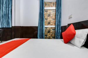 a bedroom with a bed with red pillows on it at OYO Flagship Hotel Golden Inn in Bhiwadi