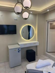 a room with a vanity and a mirror and a bed at Almir Otel in Erdemli