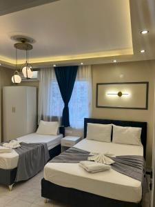 a bedroom with two beds and a window at Almir Otel in Erdemli