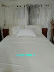 a white bed with the words love den on it at Love Den in Christ Church