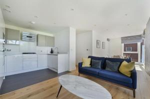 a living room with a blue couch and a kitchen at Luxury Collection - Borough/ Tower Bridge in London