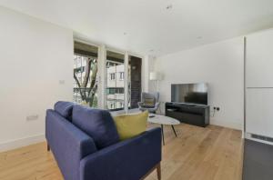 a living room with a blue couch and a tv at Luxury Collection - Borough/ Tower Bridge in London