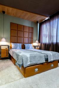 a bedroom with a large bed with a wooden headboard at Studio77 in Veliko Tŭrnovo