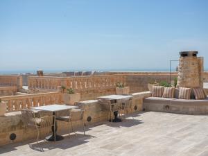 eine Terrasse mit Tischen und Stühlen auf dem Dach in der Unterkunft Mirsoum Han in Mardin