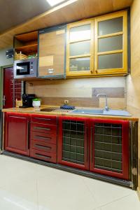a kitchen with red cabinets and a sink at Studio77 in Veliko Tŭrnovo