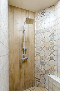 a shower in a bathroom with a wooden wall at Studio77 in Veliko Tŭrnovo