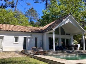 een huis met een zwembad en een patio bij Villa DUNE in Biscarrosse